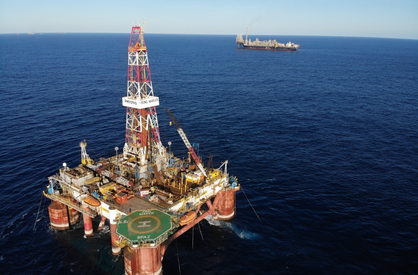 Imagem de uma plataforma de petróleo da PRIO no mar e ao funto um navio