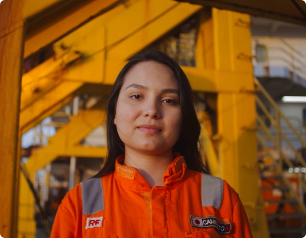 Uma mulher com uma jaqueta laranja em plataforma de petróleo da PRIO