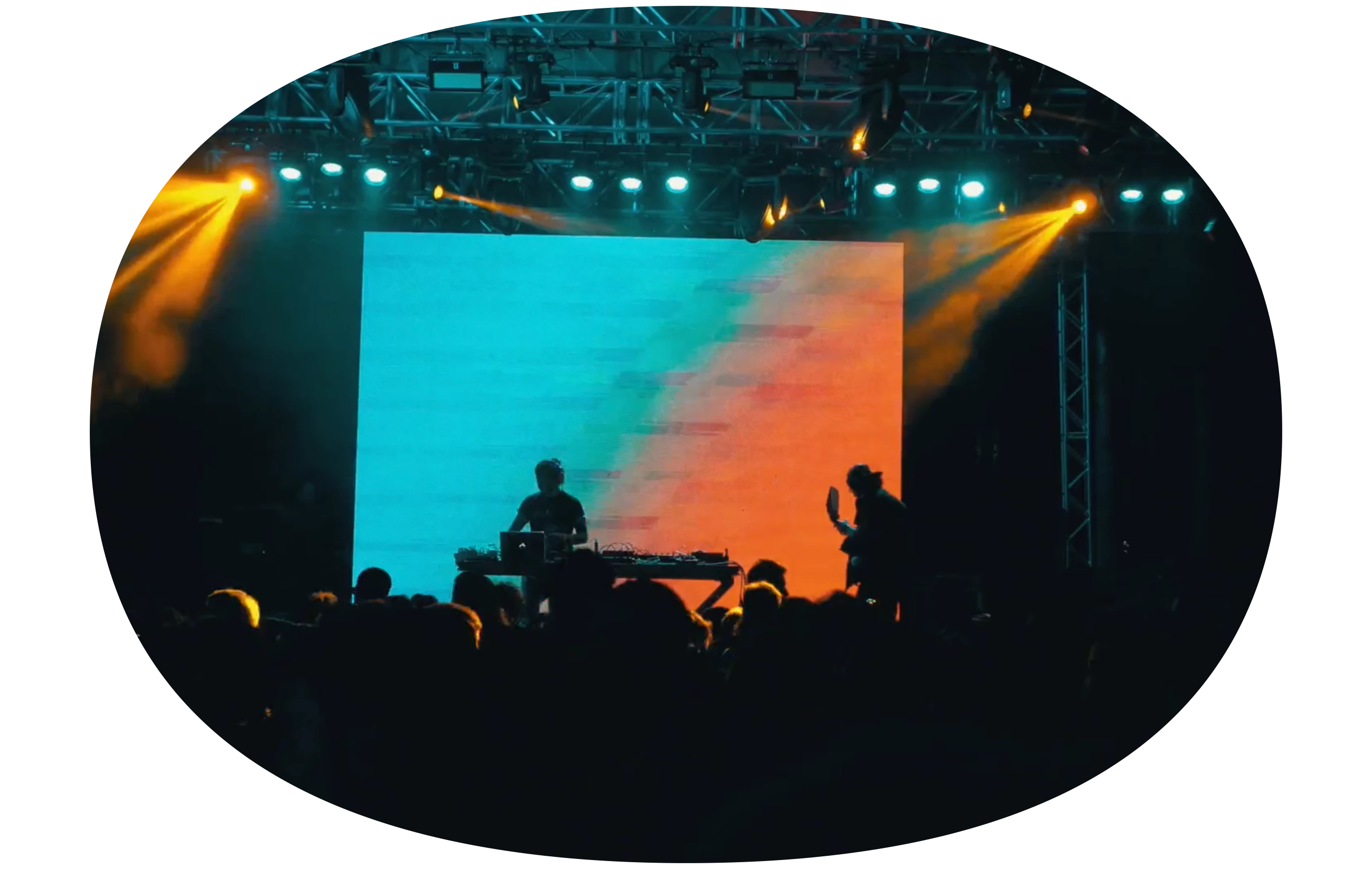 Imagem de uma palco com um DJ tocando para o público