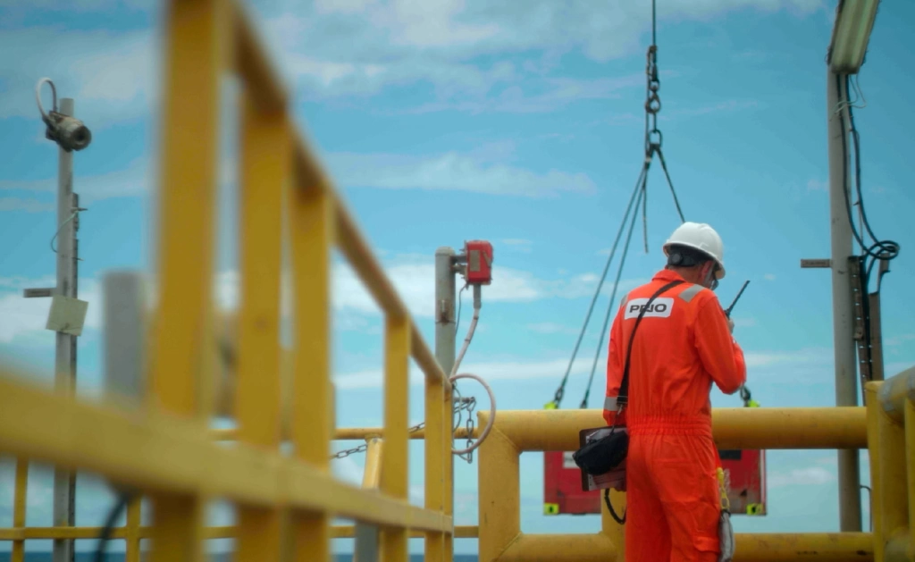 Imagem de um trabalhador da PRIO de costas em uma plataforma de petróleo