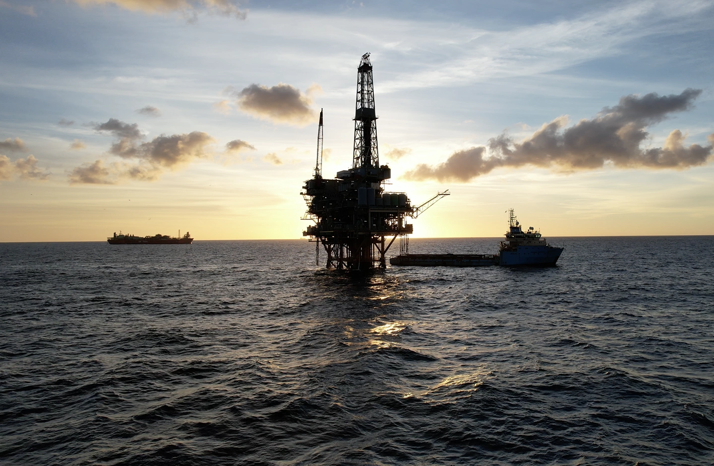Uma plataforma de petróleo no meio do oceano ao por do sol